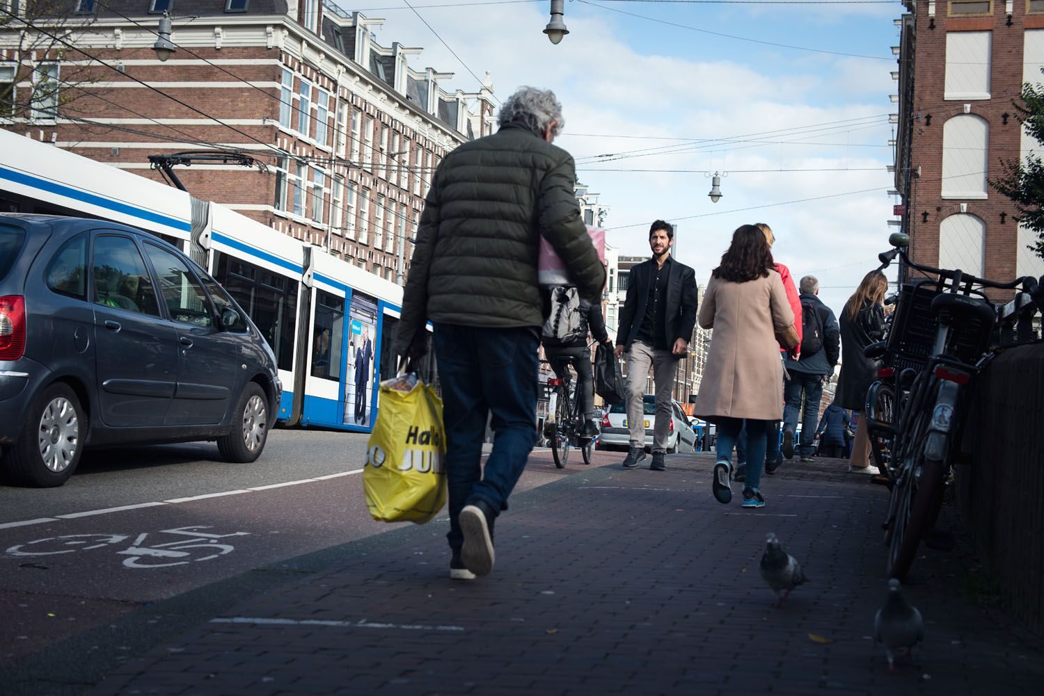 Eran Harash, oprichter van Weave projects, gefotografeerd op straat in Amsterdam, tussen de mensen voor wie hospitality bedoeld is.